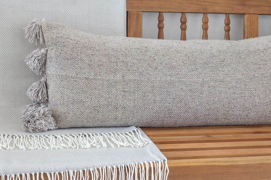 light wood bench neutral blanket and pillow