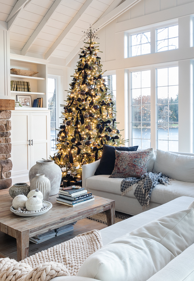 white living room with christmas tree with black and bronze ornaments 